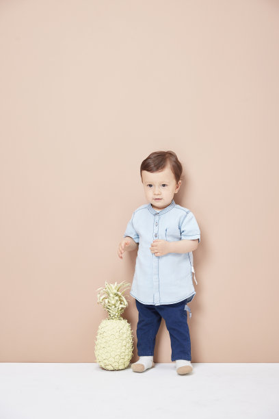 一个穿着牛仔裤的小男孩，一件在他膝盖前看起来很可爱的衬衫。图片下载