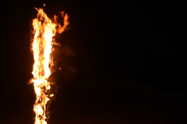 黑色背景前的火焰柱图片下载