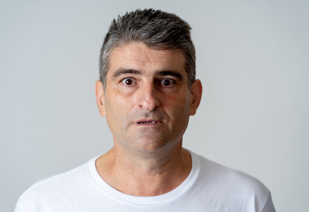 肖像的一个40岁50岁的男人在震惊与恐惧的表情在他的脸上做人类的情感，感情和面部表情概念孤立在灰色的背景。图片下载