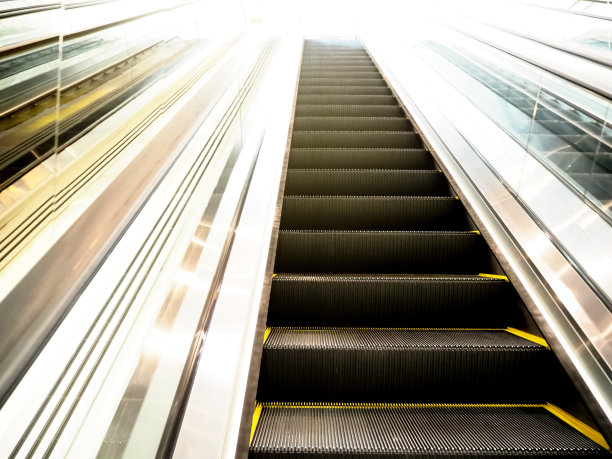 购物中心的自动扶梯。上下楼梯。电动扶梯。图片下载