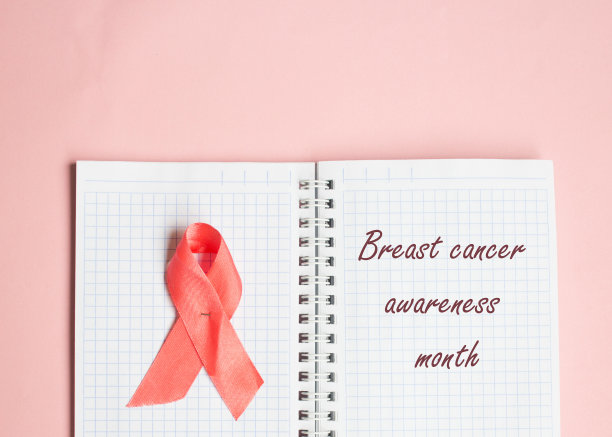 粉色丝带象征蝴蝶结色，为乳腺癌宣传月，题写在笔记本上图片下载