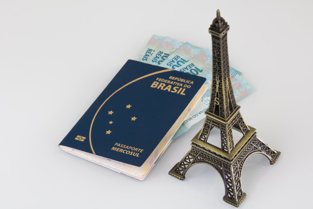 巴西护照(翻译为“巴西共和国联邦共同市场护照”)，百元钞票和埃菲尔铁塔的白色背景。图片下载