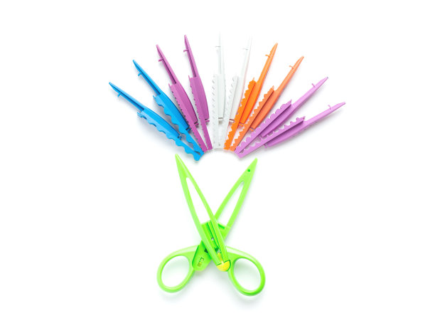 有波浪边的绿色剪刀放在中间的白色背景上，旁边是不同版本的不同边的刀片。创造力，在家里和幼儿园和孩子们一起玩。爽肤水图片下载