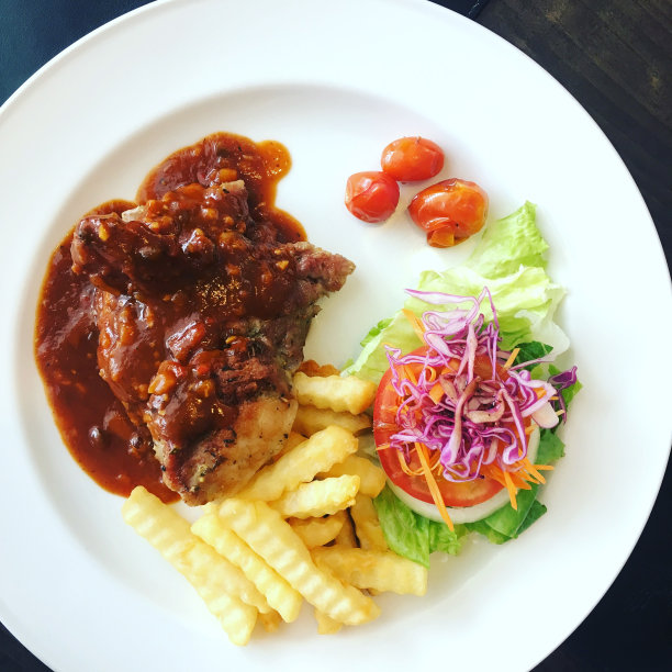 烤牛排配番茄酱，配沙拉和炸薯条。图片下载