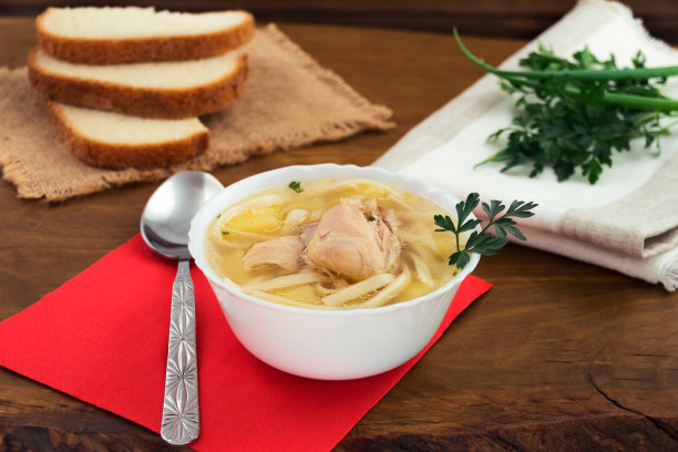 热鸡汤配面条和土豆，新鲜的欧芹和葱，白面包片。图片下载