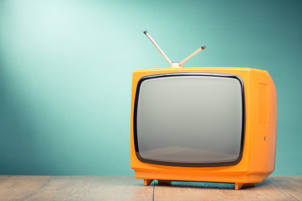 复古旧橙色电视接收器在桌子前面纹理梯度薄荷绿色背景。复古风格滤镜照片图片下载