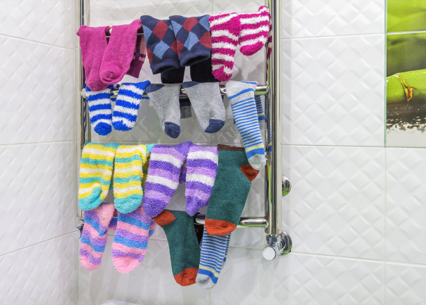 温暖的毛巾布和羊毛袜在暖气浴室散热器上烘干。家里的毛巾架。特写,有选择性的重点。图片下载