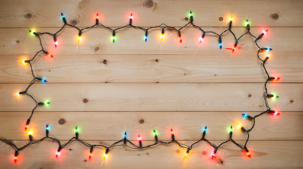 圣诞彩灯以蓝色、黄色、红色、粉色、橙色和绿色等复古风格的木纹为背景，在夜晚打开或盖上灯罩作为圣诞或新年的装饰装饰品图片下载