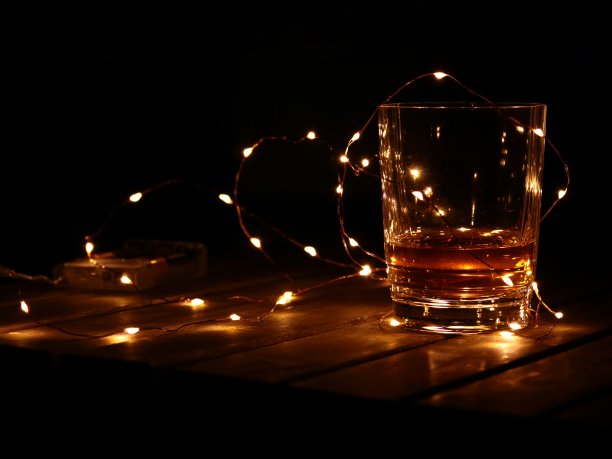 一杯威士忌配上发光的花环图片下载