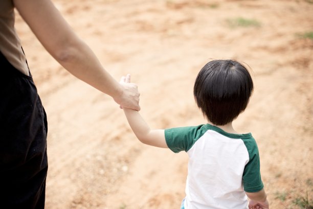 母亲牵着儿子的手:特写图片下载