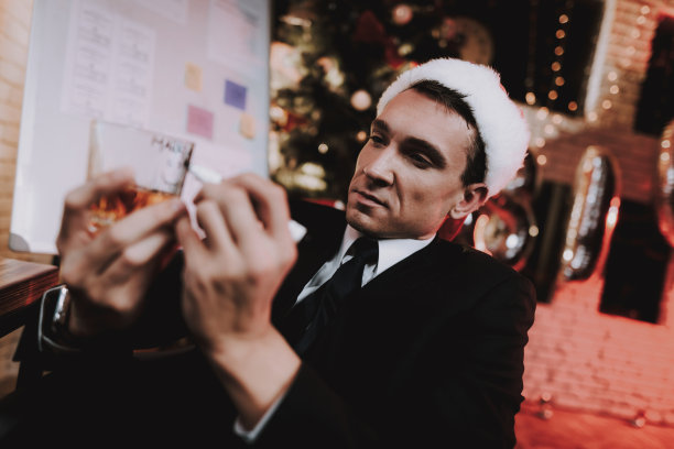 办公室里的商人在酒杯上写字。图片下载