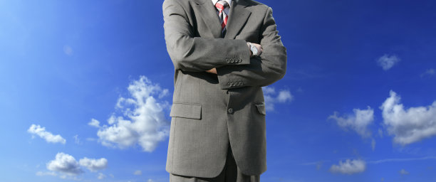 近距离的商人在西装手臂交叉在蓝天图片下载