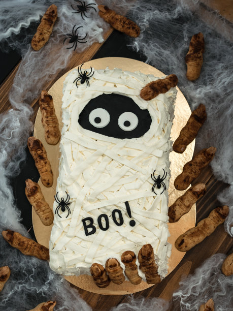 自制鬼蛋糕配女巫手指饼干。妈妈为孩子们的万圣节派对做鬼蛋糕图片下载