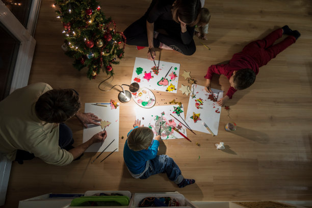 年轻的家庭庆祝圣诞节制作装饰品图片下载
