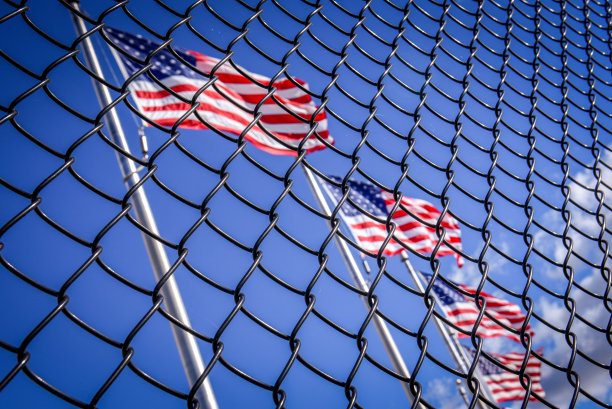 铁丝网围栏后面的美国国旗。概念上的照片。通往美国的边境墙图片下载
