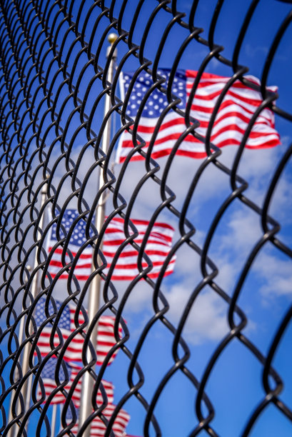铁丝网围栏后面的美国国旗。概念上的照片。通往美国的边境墙图片下载