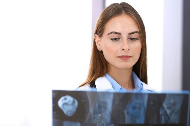 一位女医生站在医院窗户附近检查x光照片。在工作中的外科医生或整形外科医生医疗保健理念图片下载