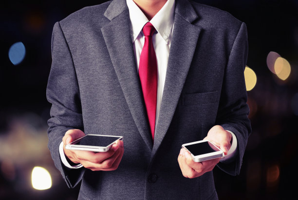 男子手持两部手机图片下载