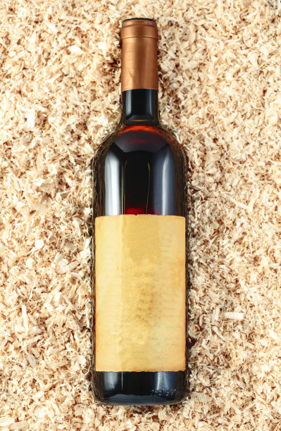 木屑背景里有一瓶葡萄酒图片下载