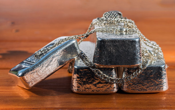 铸银条和银饰在棕色的木材纹理的背景图片下载