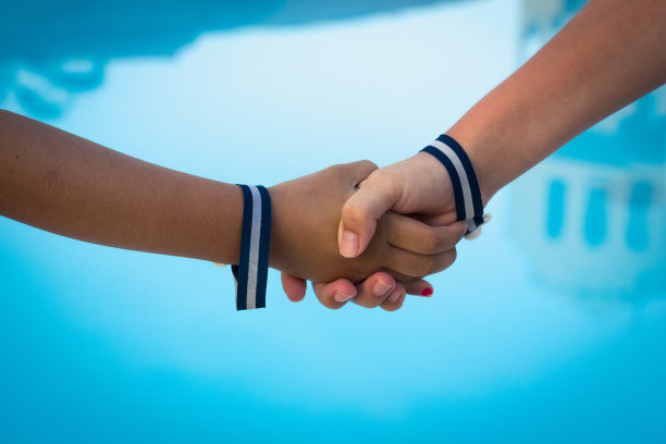 孩子们的手在蓝色的水背景上握手图片下载