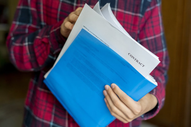 双手紧握蓝色文件夹，里面有文件，合同表图片下载