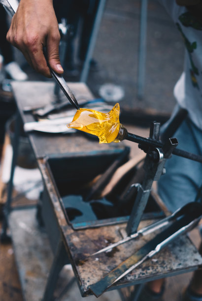 玻璃吹制工艺店。工人的双手与工具的形象。创造杰作的时刻图片下载