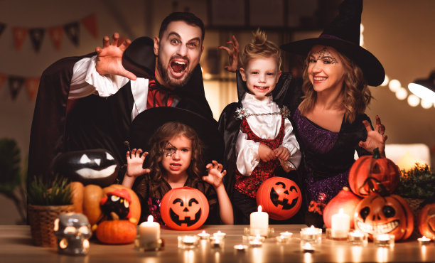 幸福的家庭妈妈爸爸和孩子们在万圣节的服装和化妆在黑暗的家里图片下载