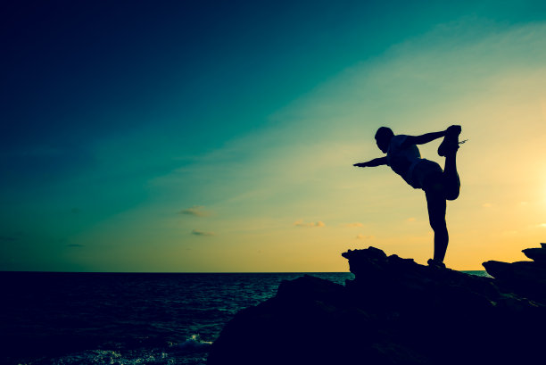 剪影女子瑜伽在山上日落。全新的一天和健康的生活方式。图片下载