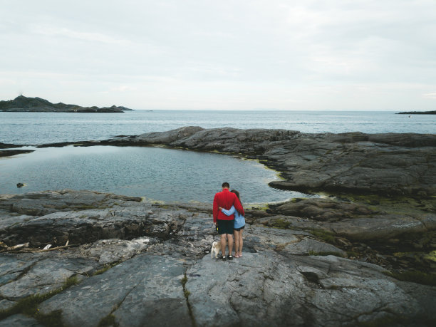 一对夫妇和一只狗在罗浮敦群岛上看海图片下载