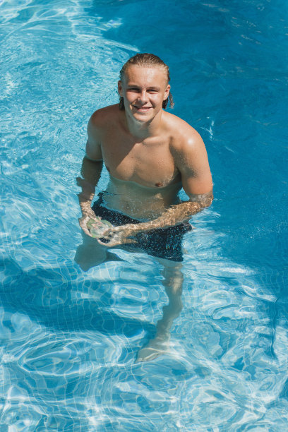 一个十几岁的男孩在游泳池里的肖像图片下载