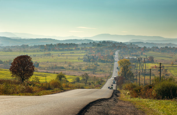 柏油路穿过山谷的田野通向山川图片下载
