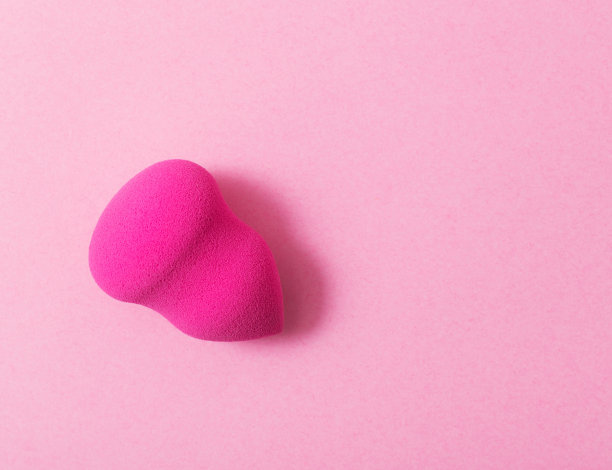 粉红色纸背景上的粉色海绵图片下载