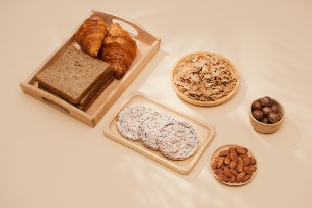 面包，小圆面包，牛奶，杏仁和新鲜牛奶的照片在桌子上与肤色背景。早餐准备，日常用品。图片下载