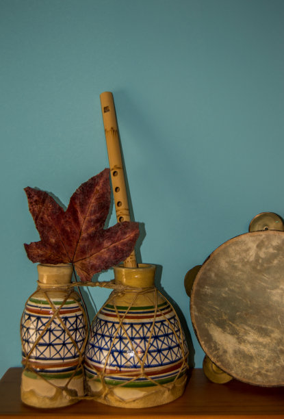 民族乐器:鼓、笛、铃鼓，干叶蓝底。手工制作的乐器。图片下载