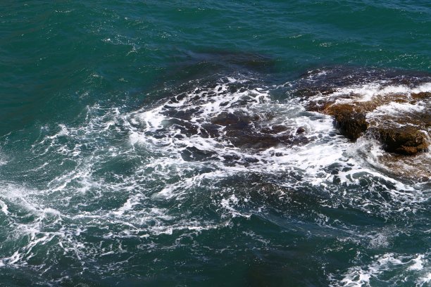 美丽的岩石浅蓝色海滩与大石头在一个夏天的一天，照片的自然图片下载