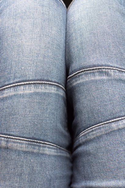 俯视图的旧牛仔裤穿在腿上。特写，牛仔纹理与接缝图片下载