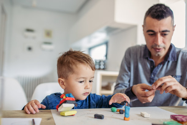 父亲和儿子在玩孩子的玩具粘土图片下载