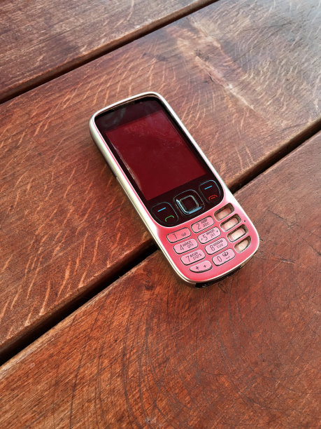 木头表面上的旧手机图片下载