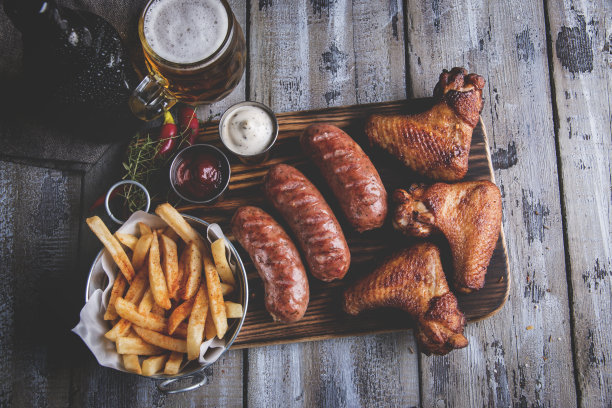 炸鸡翅，香肠，薯条，坚果，白酱和红酱。啤酒组图片下载