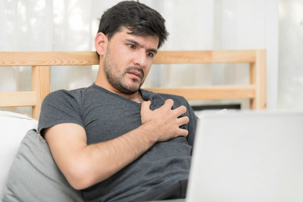 成熟的男人在用笔记本电脑搜索“卧室基本帮助”时，担心自己会遭受心脏疼痛。保护心脏病。慢性心力衰竭急性加重的概念图片下载