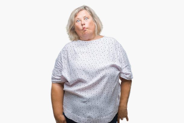 年长的加尺寸的白人妇女在孤立的背景使鱼脸与嘴唇，疯狂和滑稽的手势。有趣的表情。图片下载