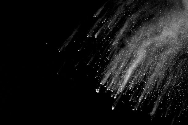 黑色背景上的白色尘埃爆炸。图片下载