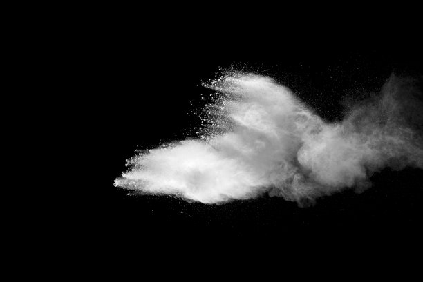 黑色背景上的白色尘埃爆炸。图片下载