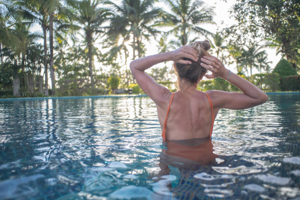 女孩享受度假水疗健康在热带天堂-女人放松池户外在豪华度假水疗撤退。快乐的年轻女模特放松休息在水上度假旅游。图片下载