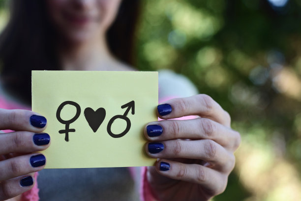 女人展示一个记事本，性别平等的概念。图片下载