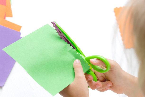 孩子们的手用剪子剪出彩纸。儿童活动，休闲。图片下载