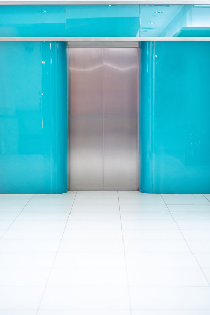 电梯设计在办公室的蓝色墙壁。图片下载