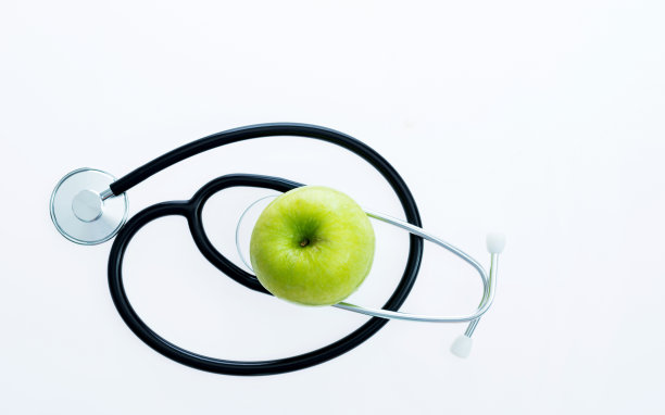 听诊器和绿苹果在白色的背景图片下载