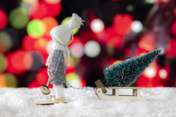 一个滑雪者拖着带着圣诞树的雪橇图片下载